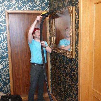 Чистка горячим паром в Риге мойщик чистит зеркало с помощью пара