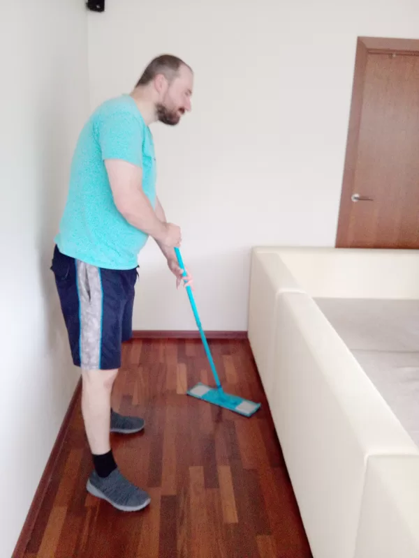 Услуги уборки: уборщик протирает влажной щеткой пол сервис: Рига, Юрмала, Латвия.